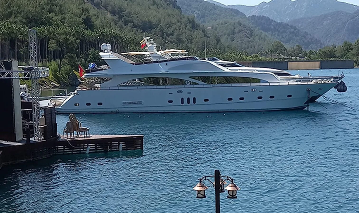 a large white yacht docked at a pier aboard AKSER Yacht for Sale