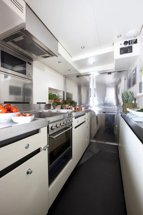 a kitchen with white cabinets aboard INTI CUBE Yacht for Sale