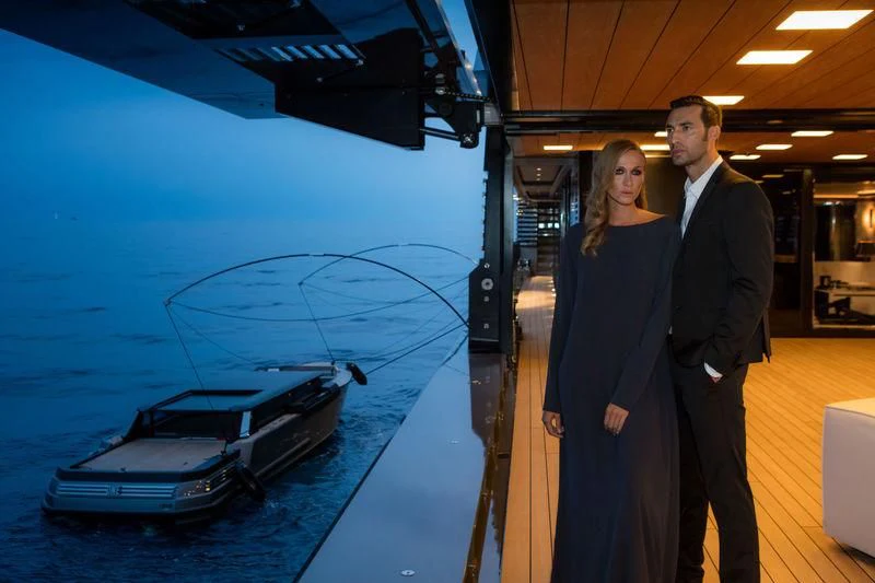 a man and woman standing next to a large model of a boat aboard ATLANTE Yacht for Sale