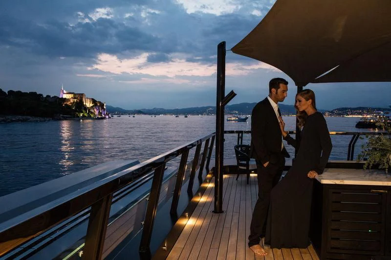 a man and woman standing on a deck overlooking a body of water aboard ATLANTE Yacht for Sale