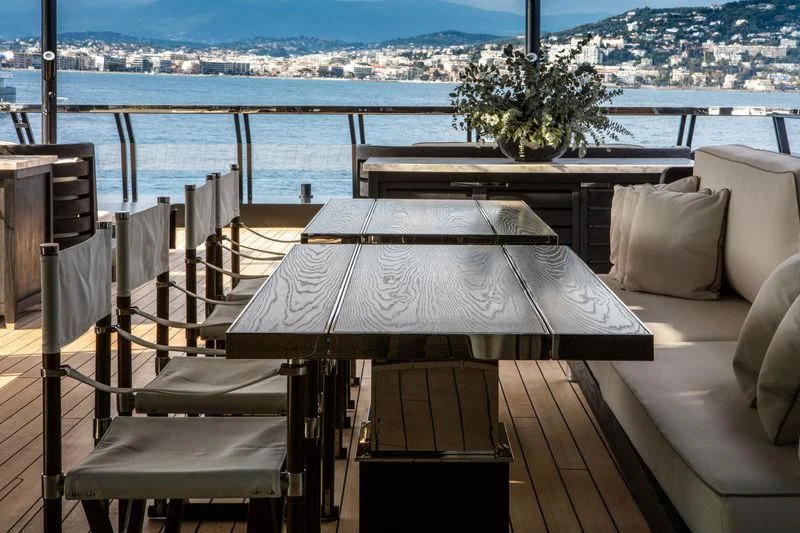 a table and chairs on a balcony overlooking a city aboard ATLANTE Yacht for Sale