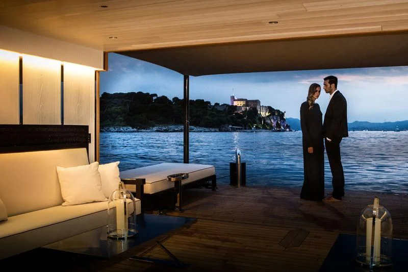 a couple of people standing on a deck overlooking a body of water aboard ATLANTE Yacht for Sale