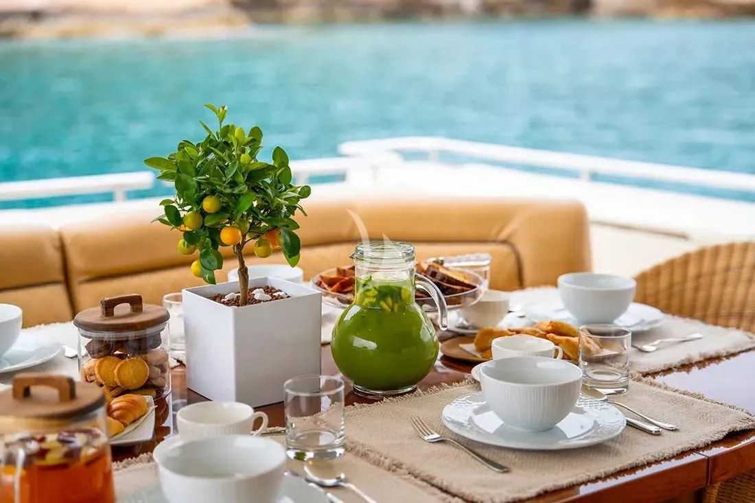 a table with food and drinks on it aboard BELLAS BOY Yacht for Sale