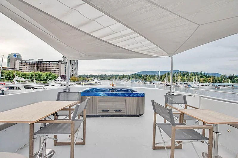 a pool table and chairs in a room with a large building in the background aboard ASCENTE Yacht for Charter