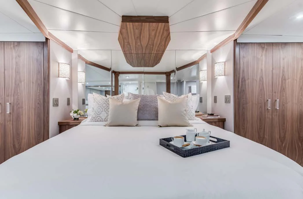 a bed with a white bed spread aboard ASCENTE Yacht for Charter