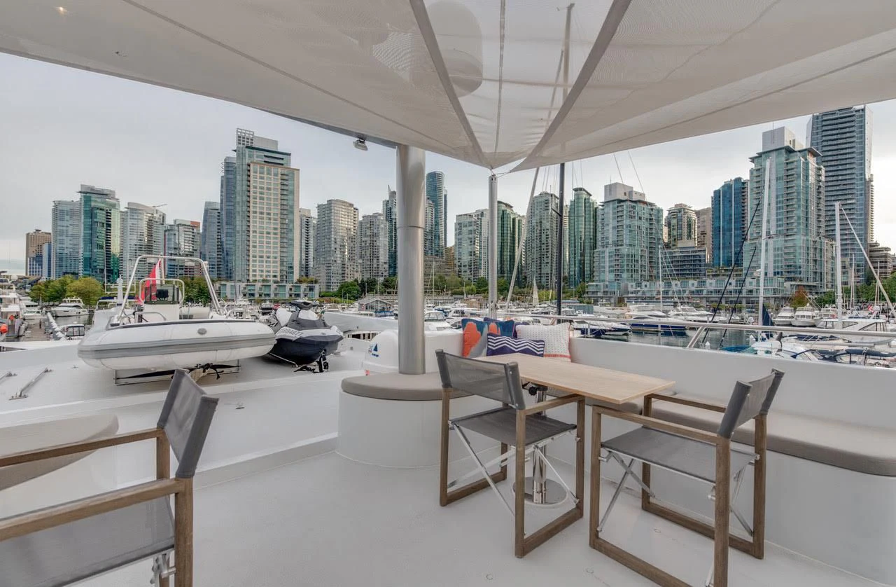 a table and chairs on a deck overlooking a city aboard ASCENTE Yacht for Charter