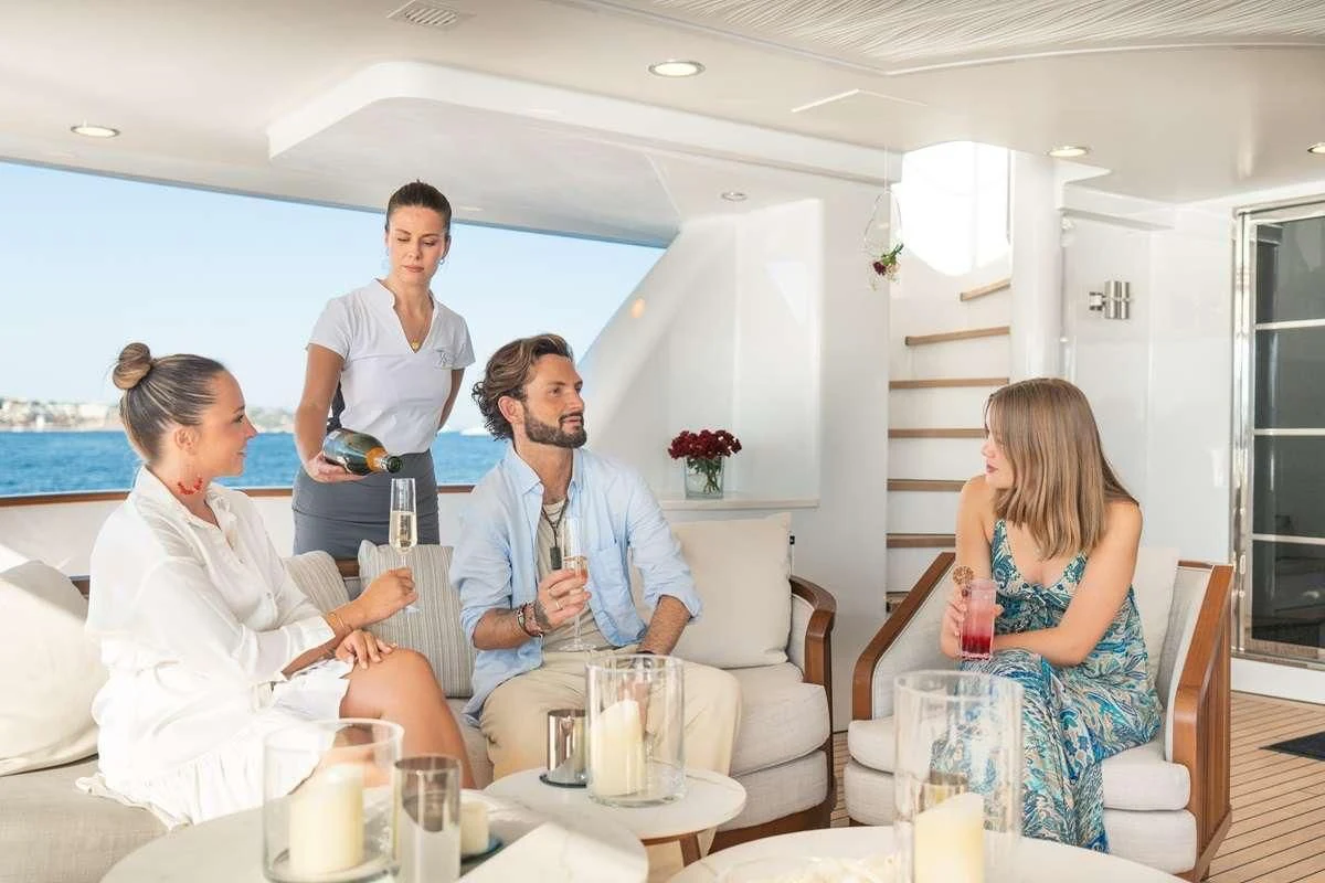 a group of people sitting around a table aboard TITIAN PEARL Yacht for Sale