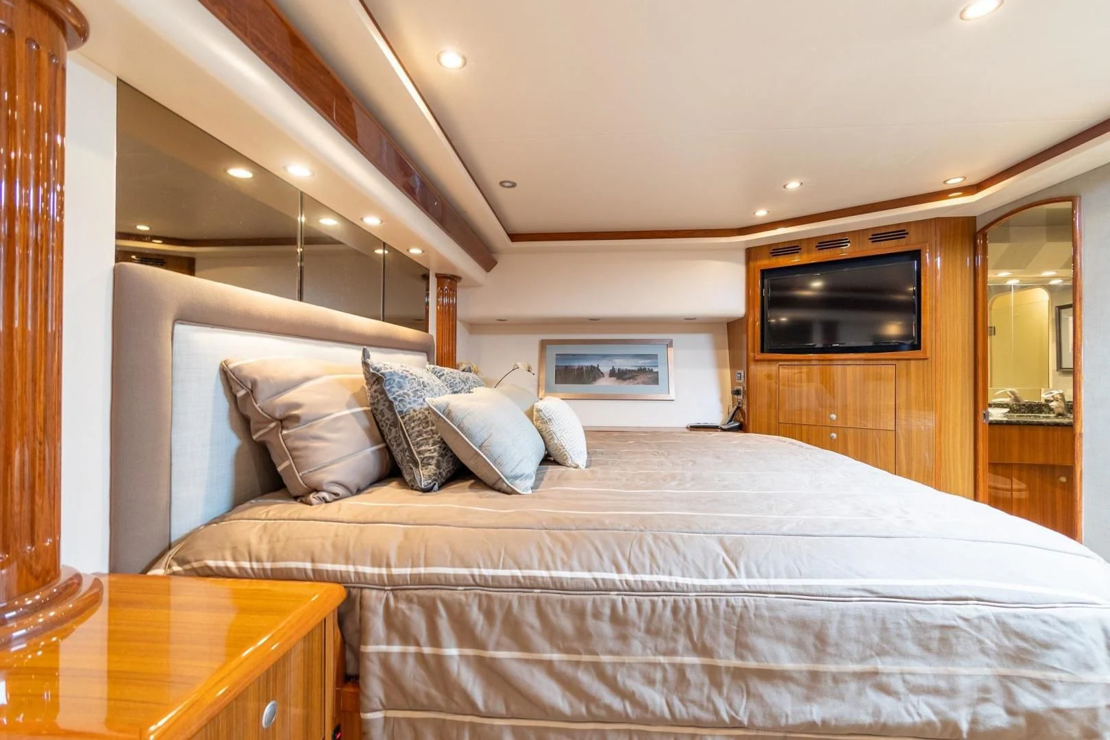 a bed with a white sheet and pillows in a room with wood cabinets aboard HOME RUN Yacht for Sale