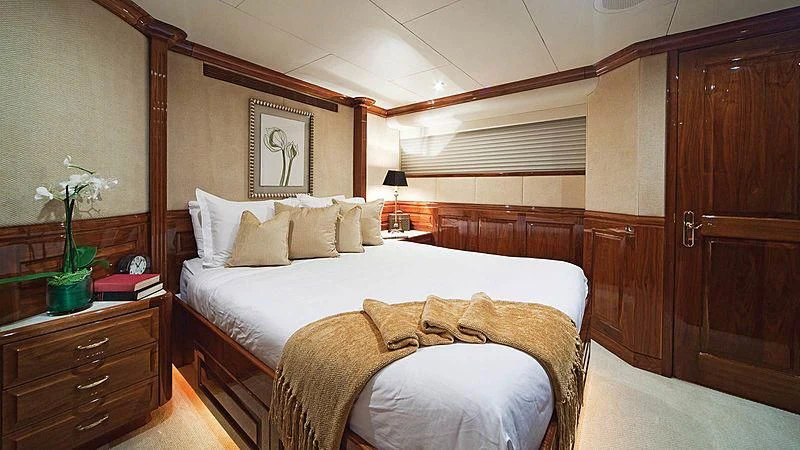 a room with a bed and a dresser aboard POPEYE Yacht for Sale