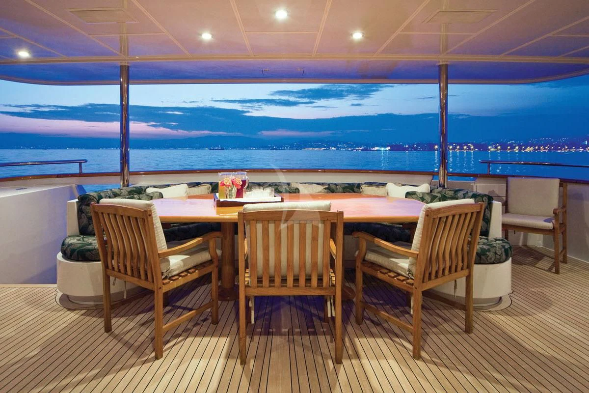 a table and chairs on a deck overlooking a body of water aboard POPEYE Yacht for Sale