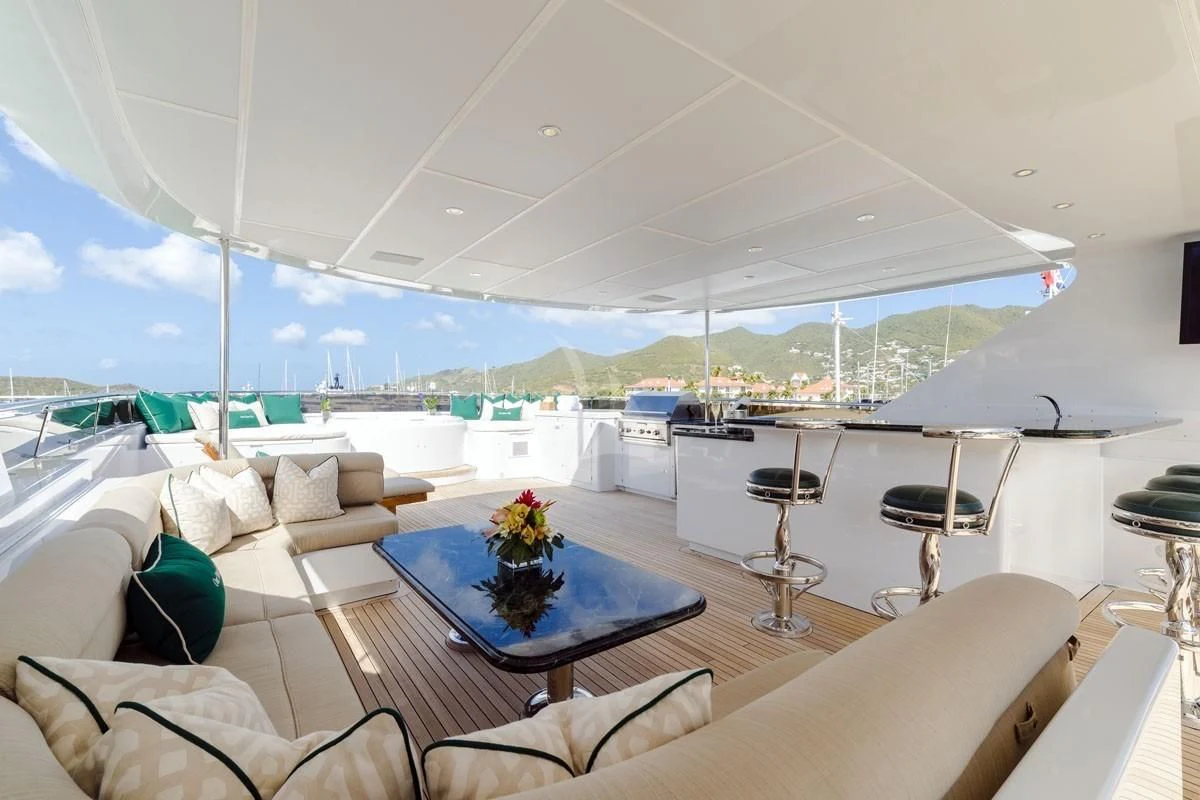 a large white lounge area with a table and chairs and a large blue and white table with a aboard POPEYE Yacht for Sale