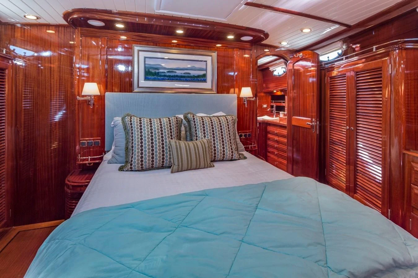 a bed with blue sheets aboard REVELRY Yacht for Sale
