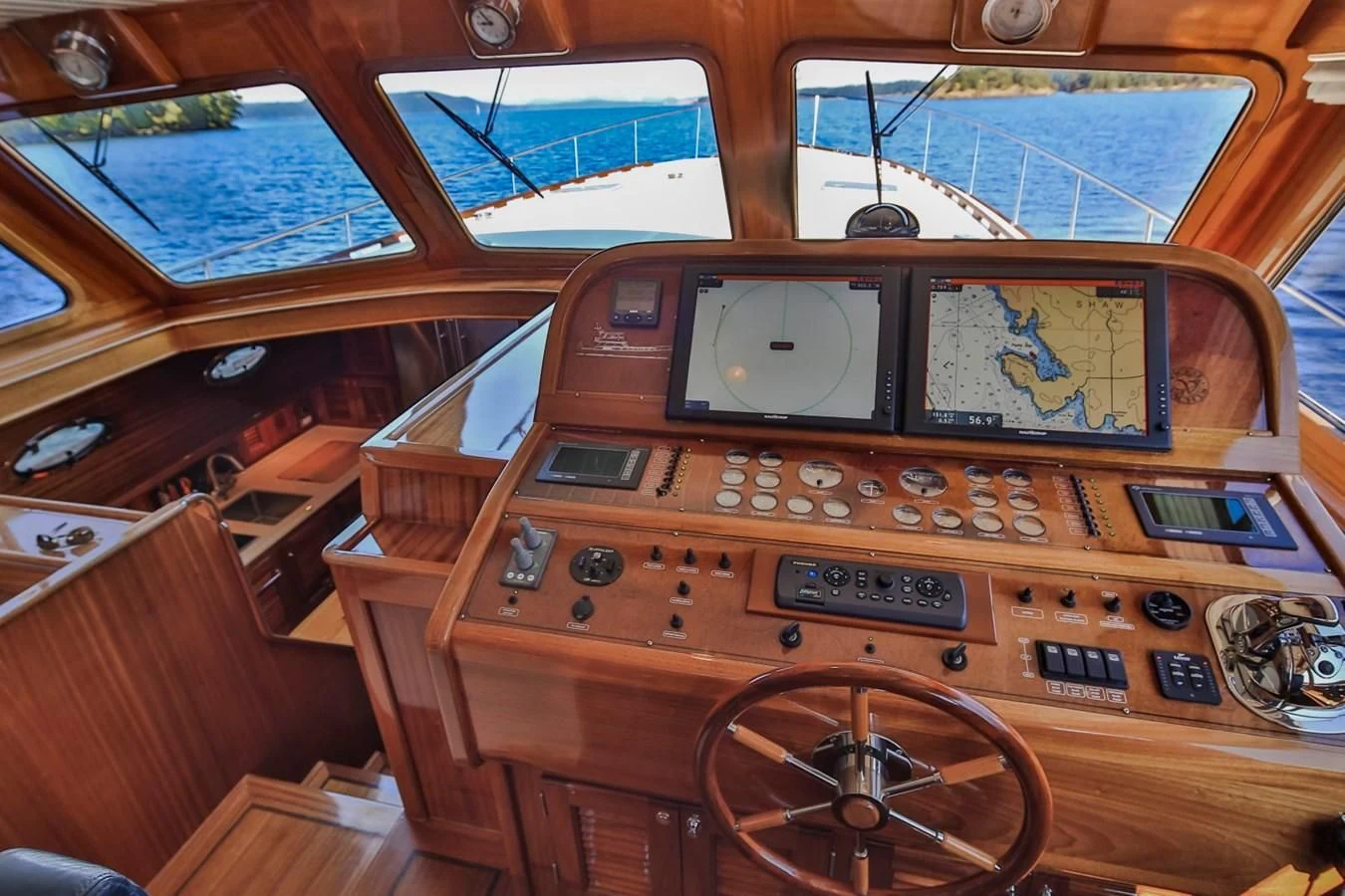 a wooden cockpit with a wooden steering wheel and wooden paneling aboard REVELRY Yacht for Sale