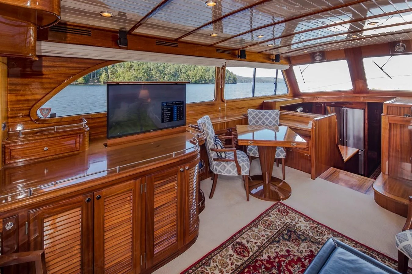 a room with a tv and chairs aboard REVELRY Yacht for Sale