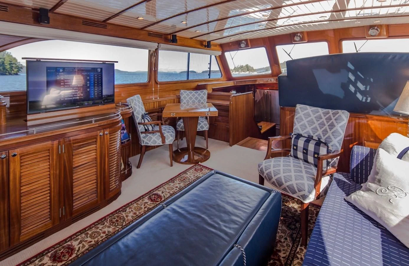 a room with a tv and chairs aboard REVELRY Yacht for Sale