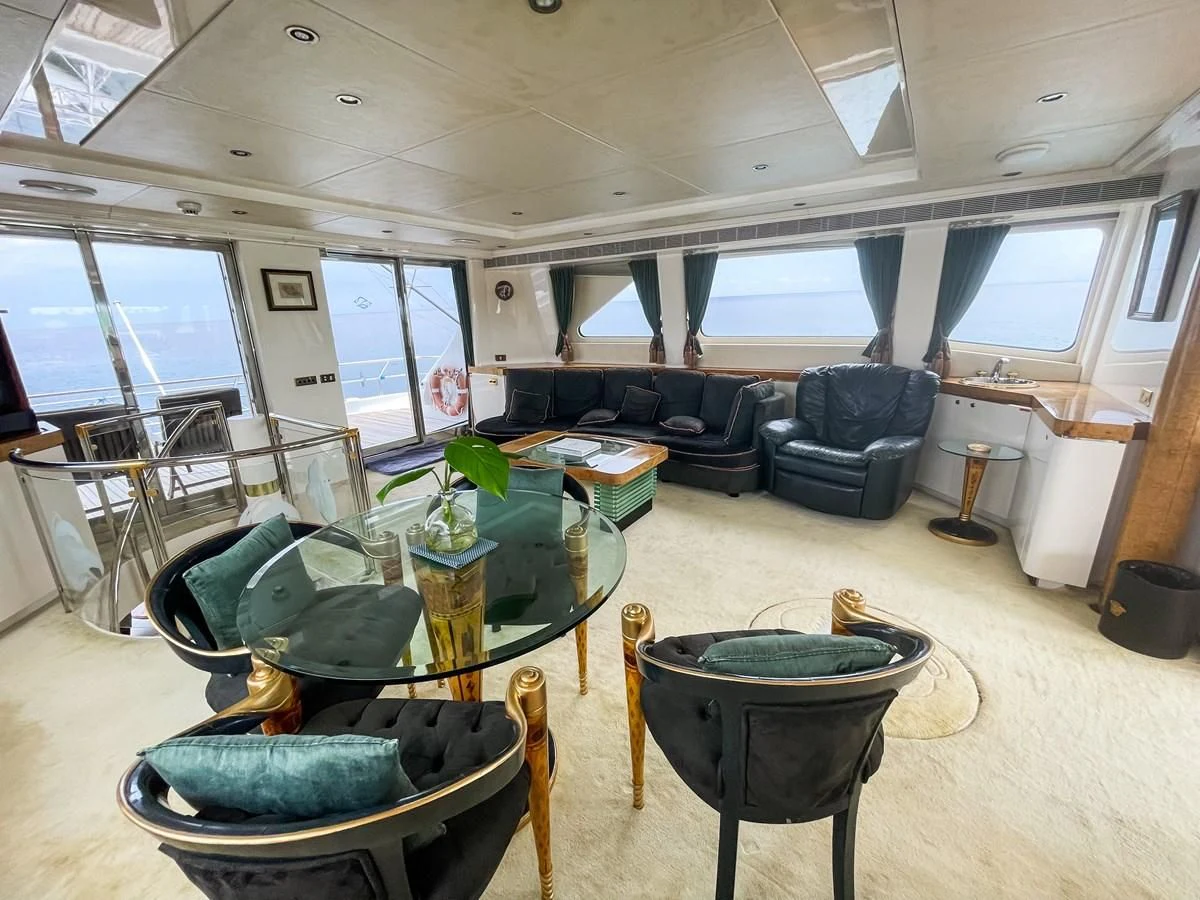 a living room with a couch and a table aboard OBSESSIONS Yacht for Sale