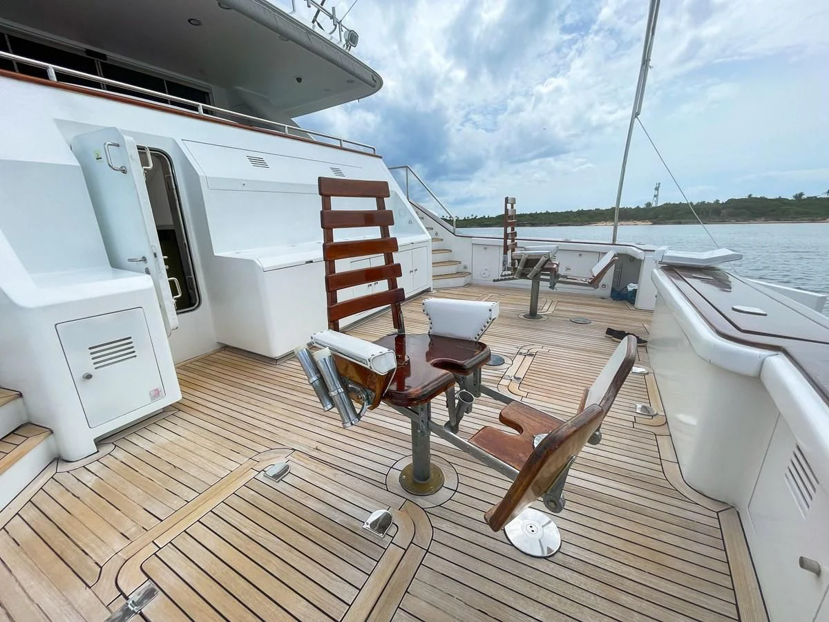 a deck with chairs and tables on it aboard OBSESSIONS Yacht for Sale