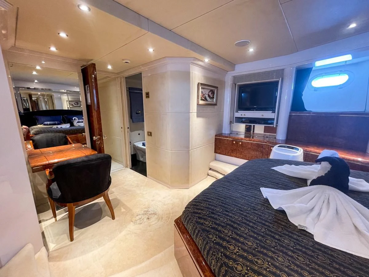 a room with a bed and a desk aboard OBSESSIONS Yacht for Sale