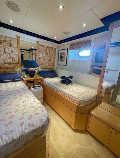 a bedroom with a bed and a window aboard OBSESSIONS Yacht for Sale