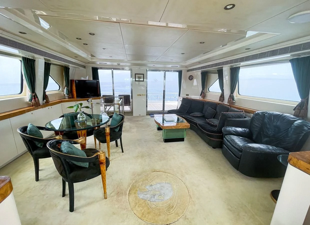 a living room with a couch and a table aboard OBSESSIONS Yacht for Sale
