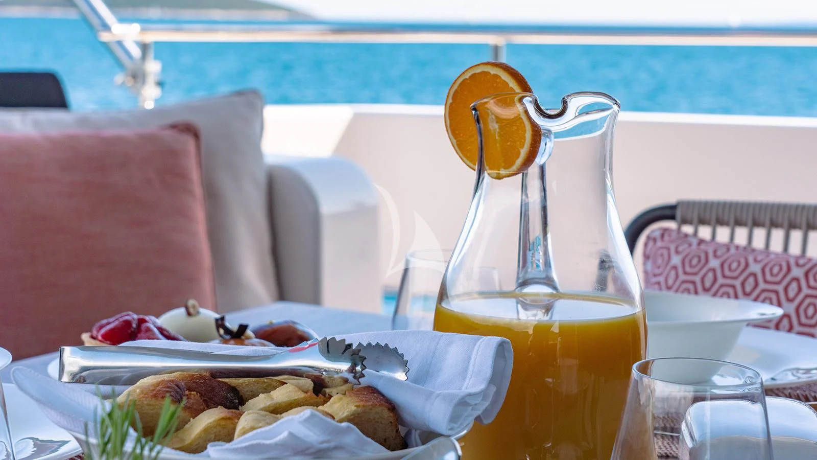 a table with food and a glass of juice on it aboard JOURNEY Yacht for Sale
