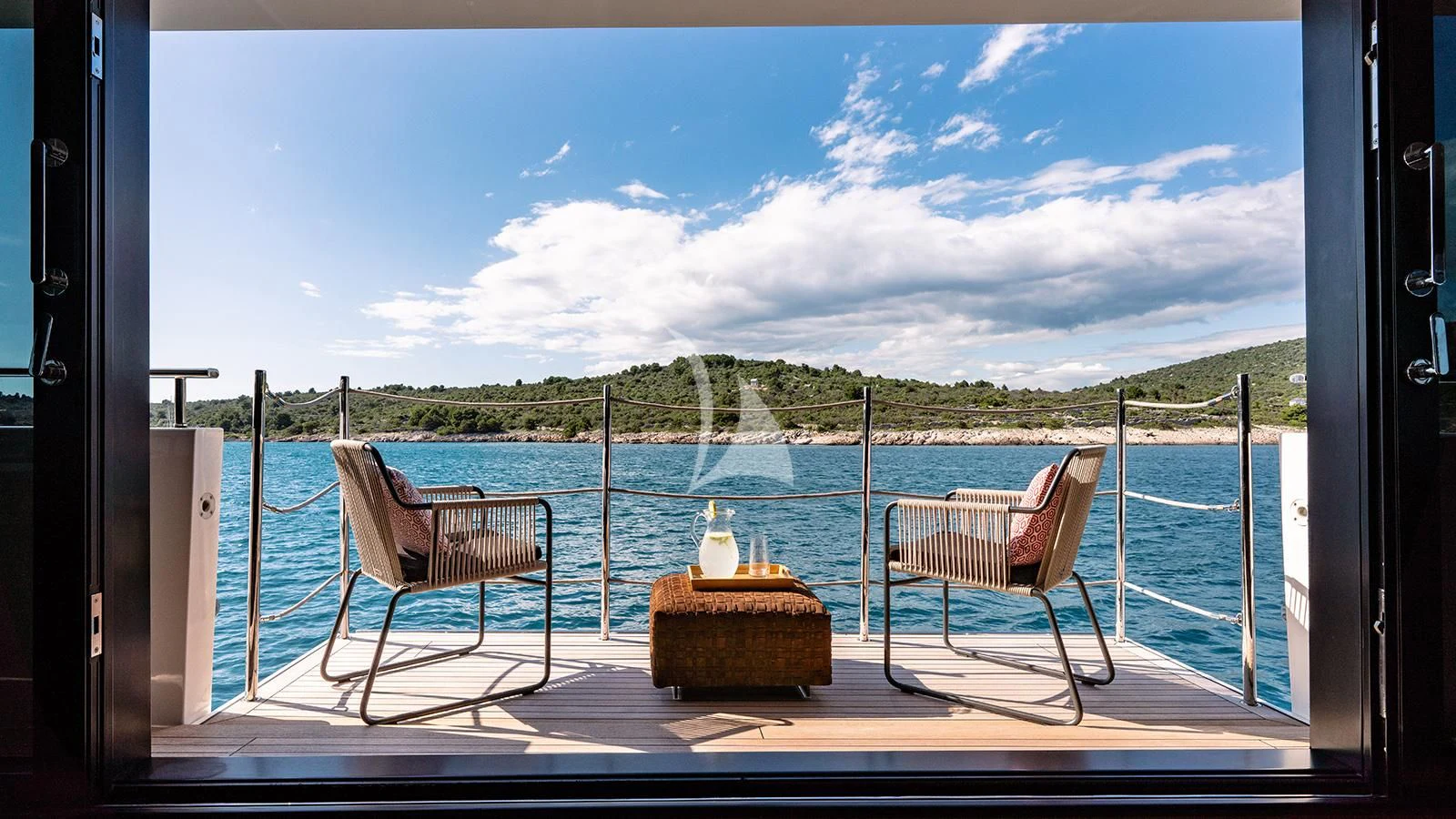 a couple chairs on a deck overlooking a body of water aboard JOURNEY Yacht for Sale