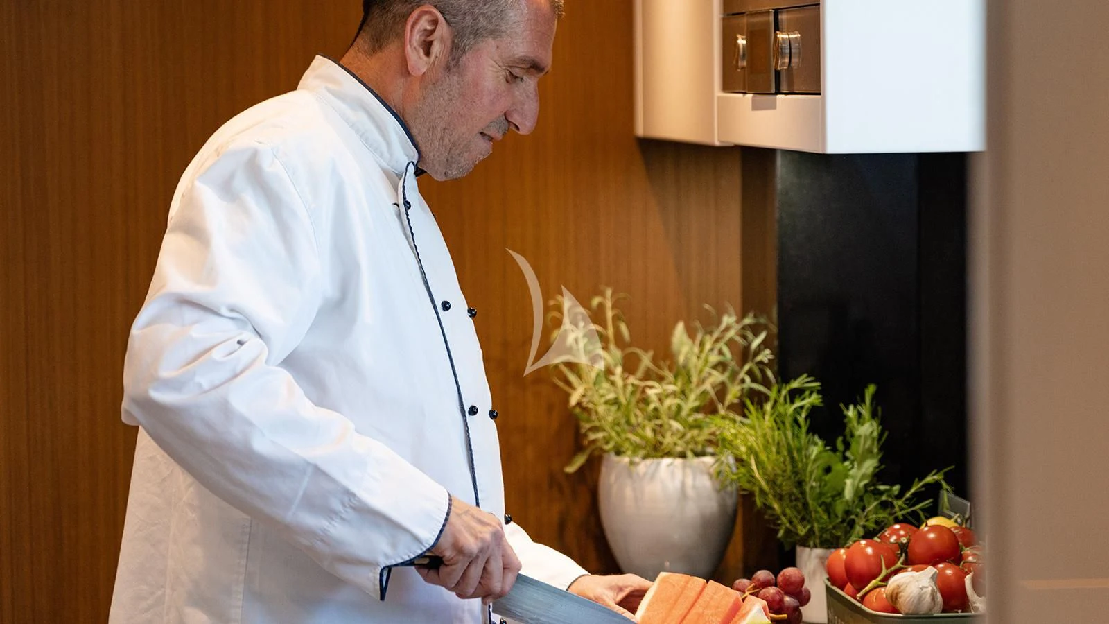 a man in a white lab coat touching a potted plant aboard JOURNEY Yacht for Sale