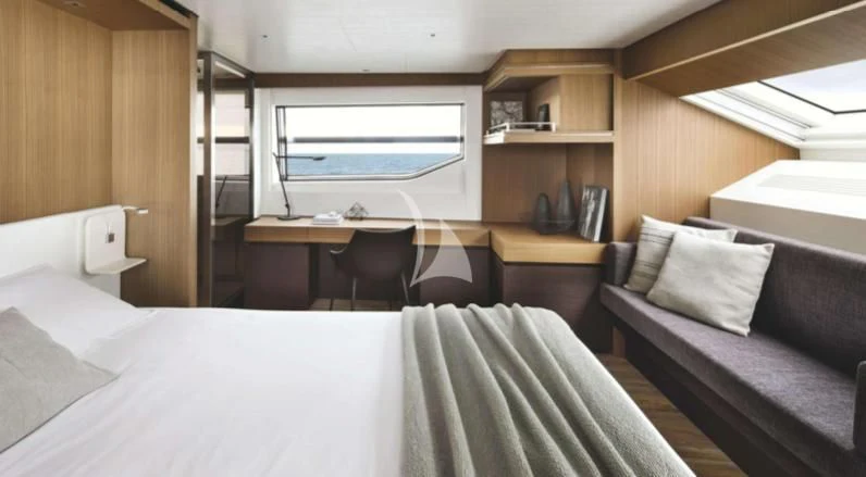 a room with a bed and desk aboard JOURNEY Yacht for Sale