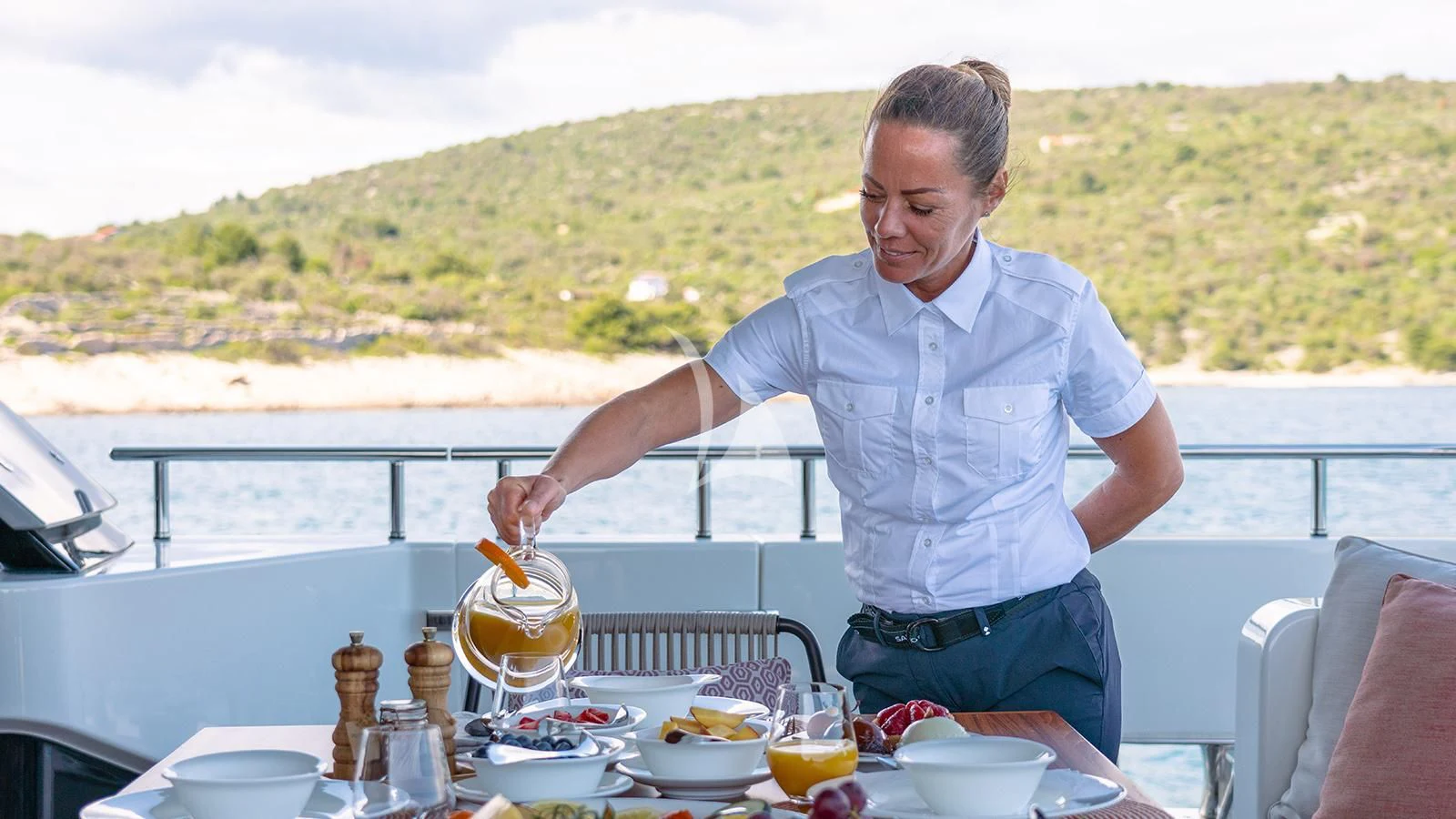 a person pouring a drink into a glass on a boat aboard JOURNEY Yacht for Sale