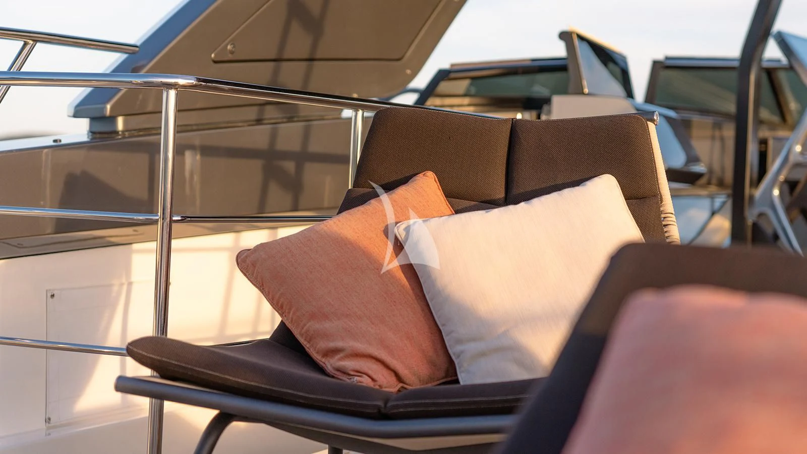 a brown pillow on a black leather chair in a bus aboard JOURNEY Yacht for Sale