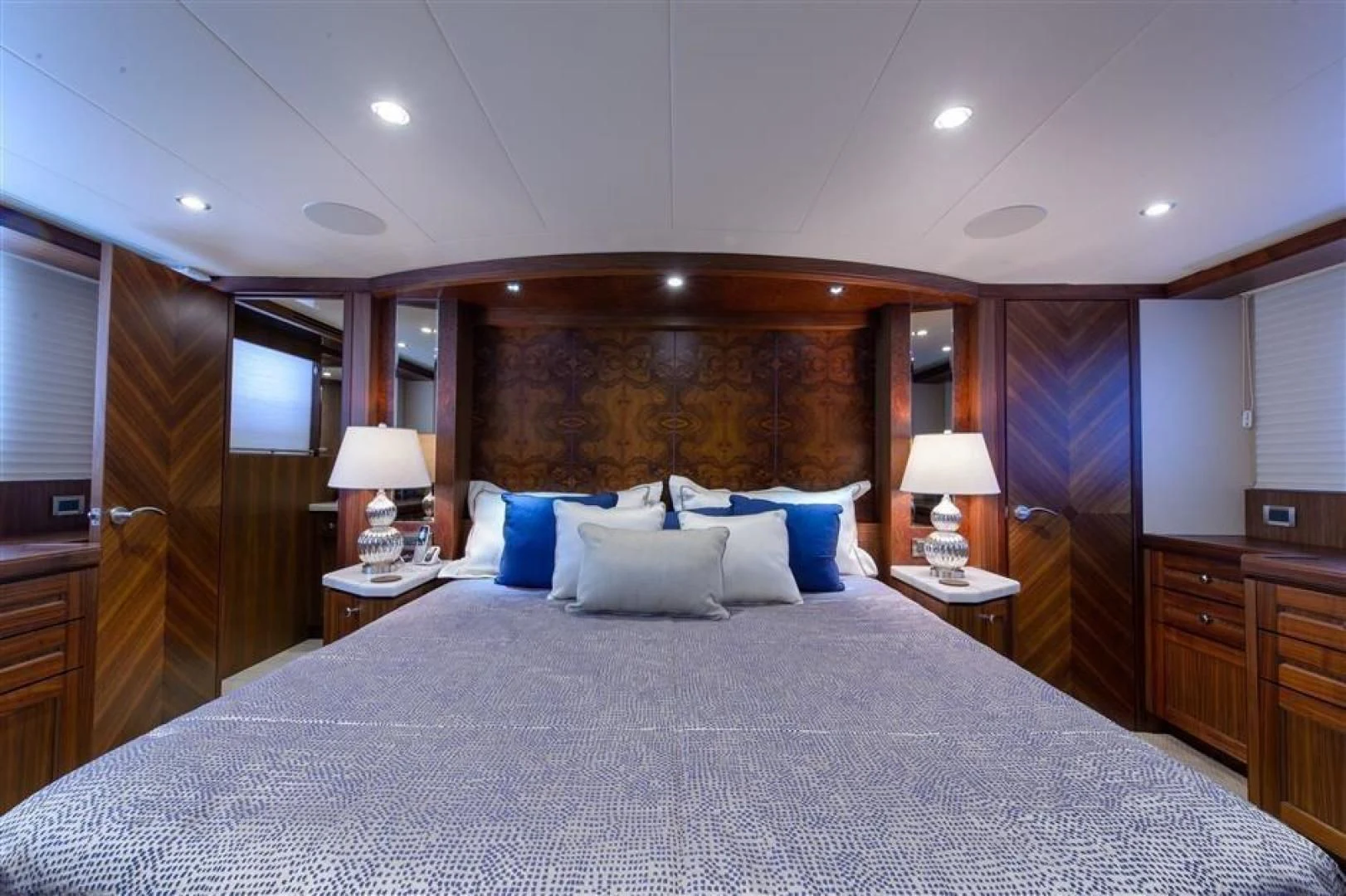 a bed with a blue and white pillow and a wooden headboard aboard RHONDAVOUS Yacht for Sale