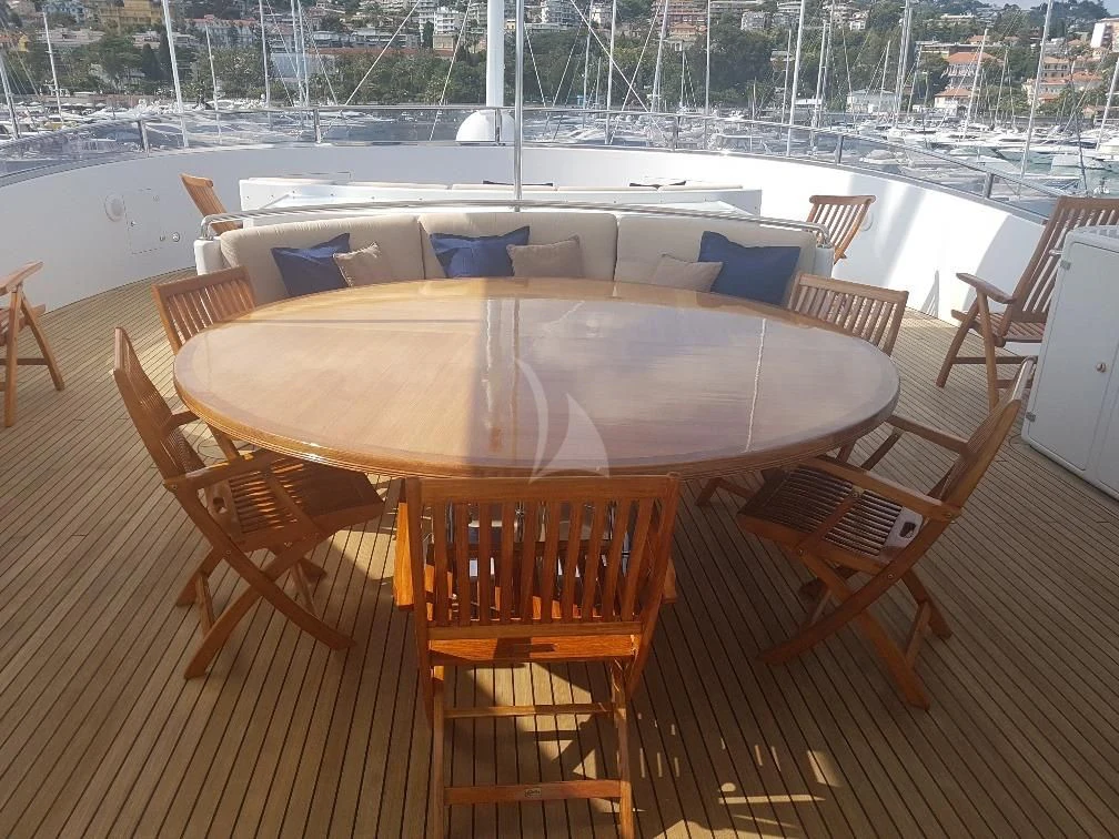 a table and chairs on a deck aboard MORE Yacht for Sale