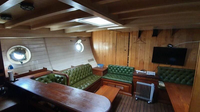 a room with a table and couch aboard ZACA A TE MOANA Yacht for Sale