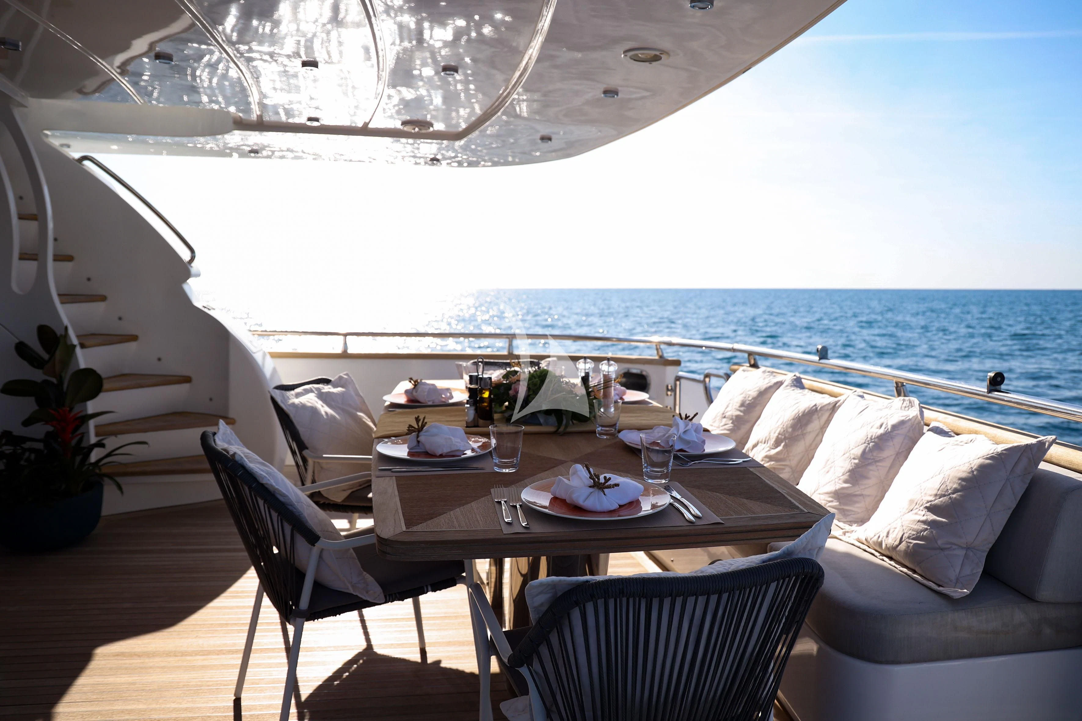 a table set for a meal on a balcony overlooking the ocean aboard WILLFUL Yacht for Sale