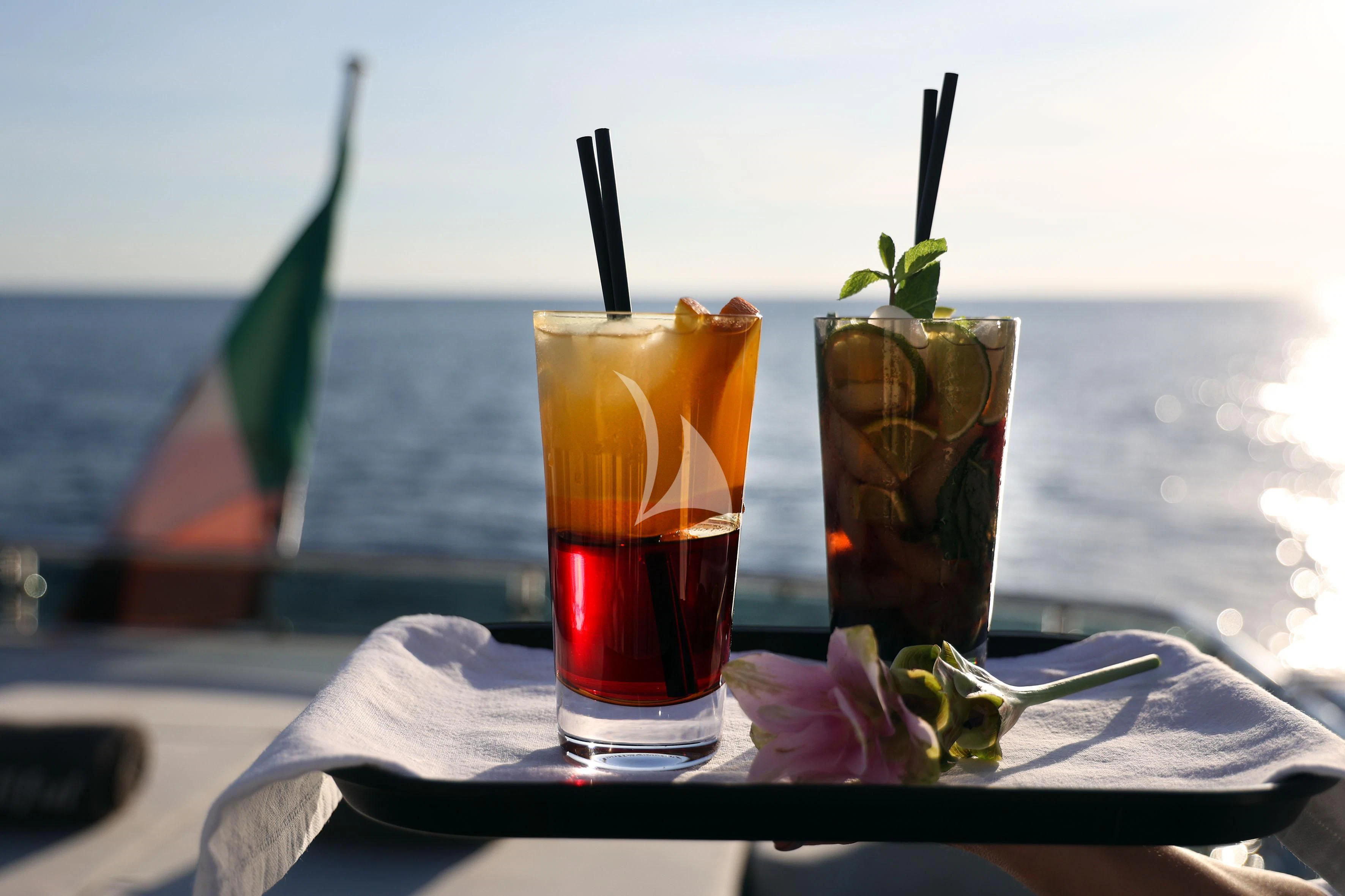 a glass of beer and a straw on a table aboard WILLFUL Yacht for Sale