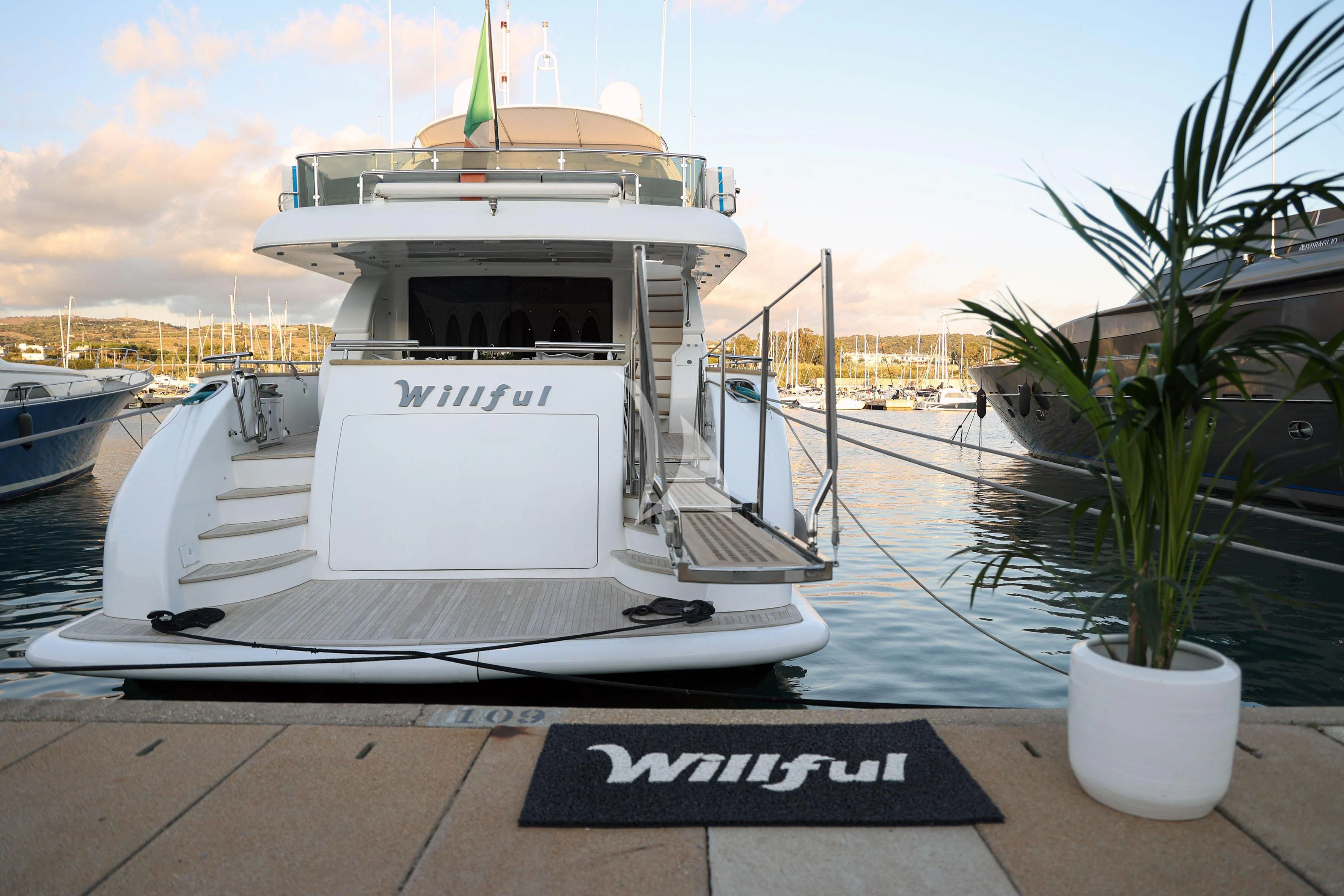 a white boat on a dock aboard WILLFUL Yacht for Sale