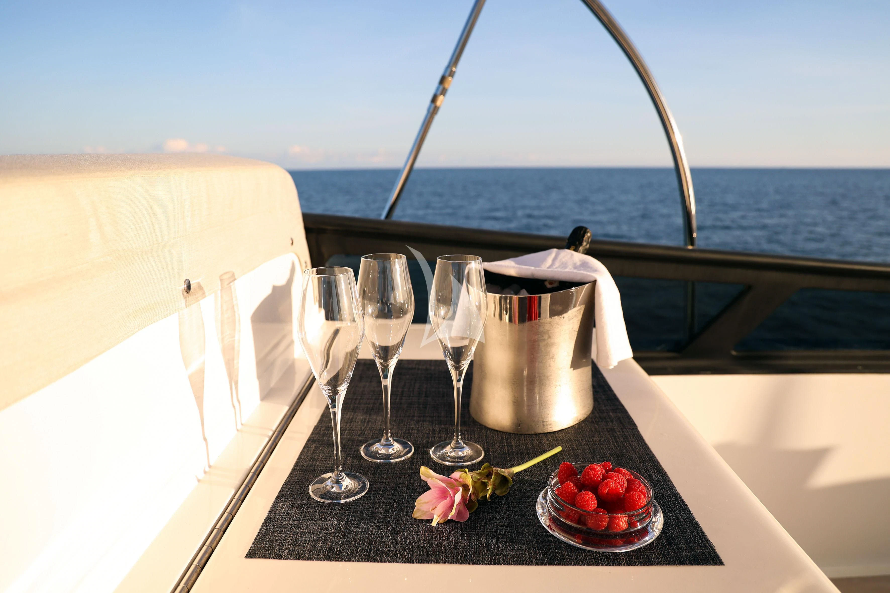 a table with wine glasses and a bottle on it aboard WILLFUL Yacht for Sale