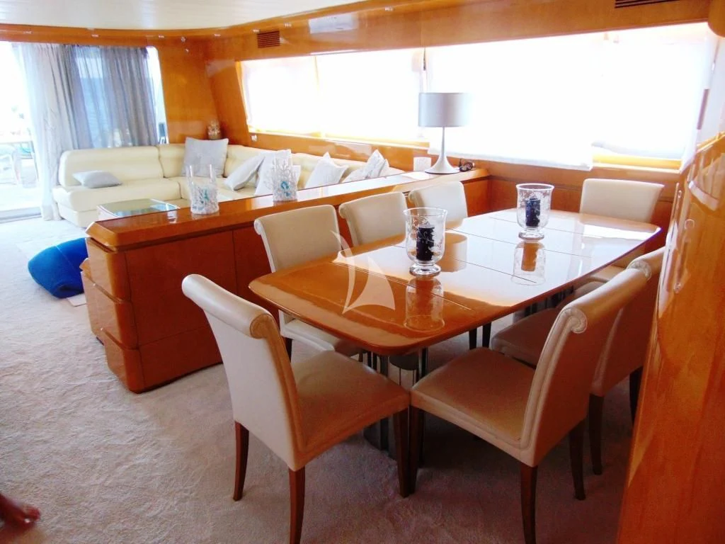 a table with chairs and a couch aboard WILLFUL Yacht for Sale