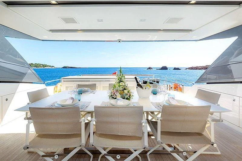 a table with chairs on it next to a large body of water aboard WANDA Yacht for Sale