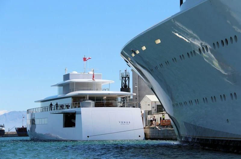 a large white ship docked aboard VENUS Yacht for Sale