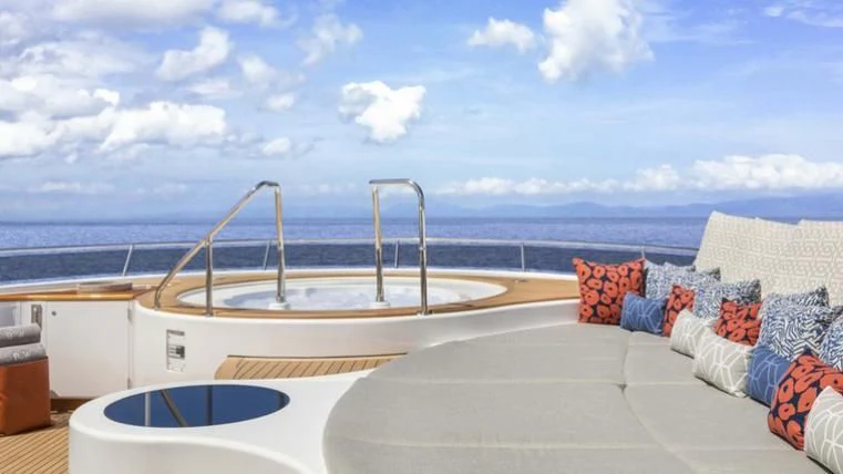 a large white tub on a balcony overlooking the ocean aboard REVERIE Yacht for Sale