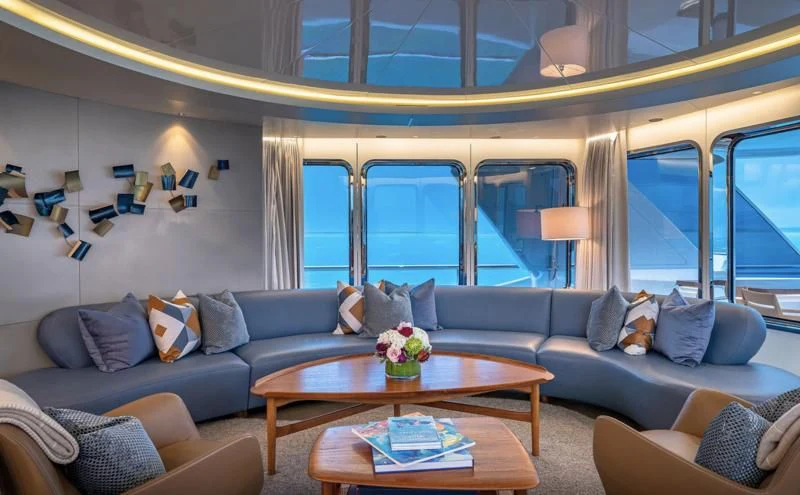 a living room with a blue couch and a coffee table aboard REVERIE Yacht for Sale
