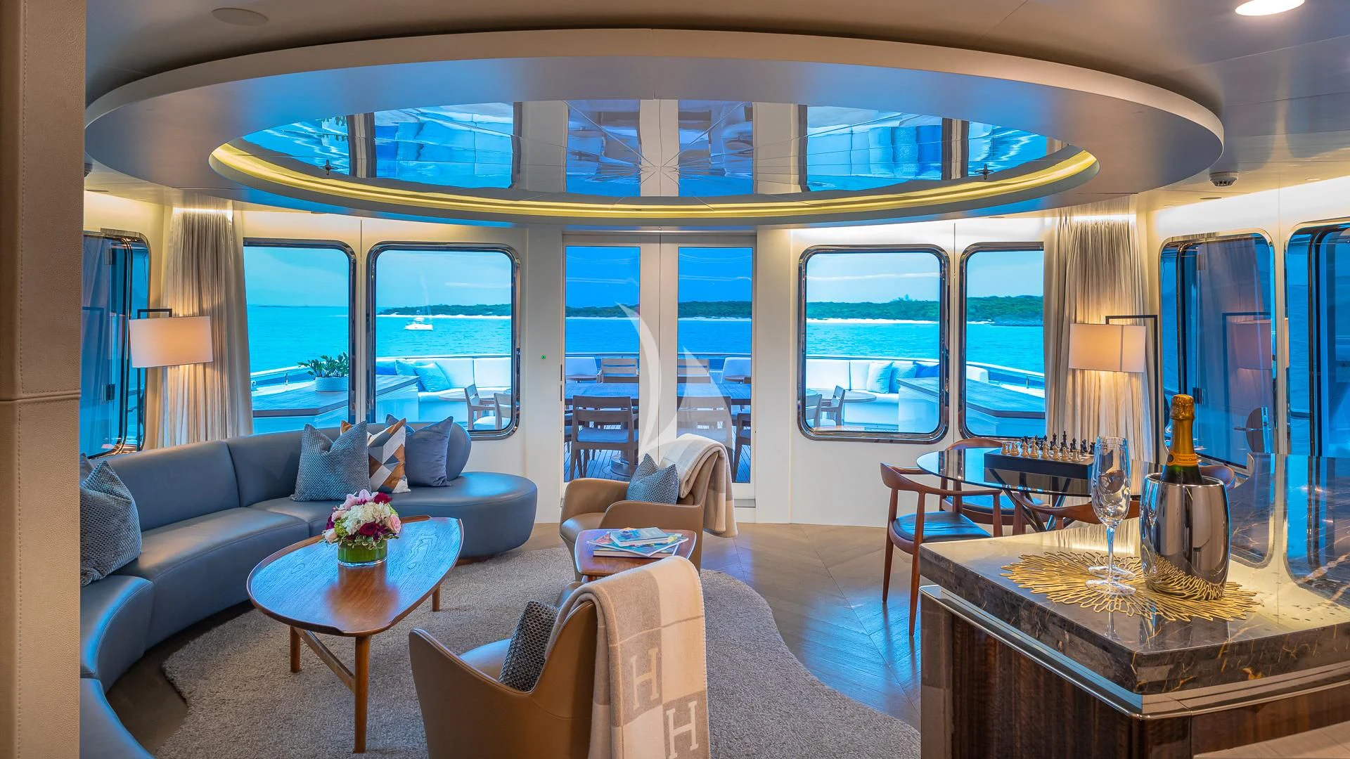 a living room with a blue couch and a coffee table aboard REVERIE Yacht for Sale