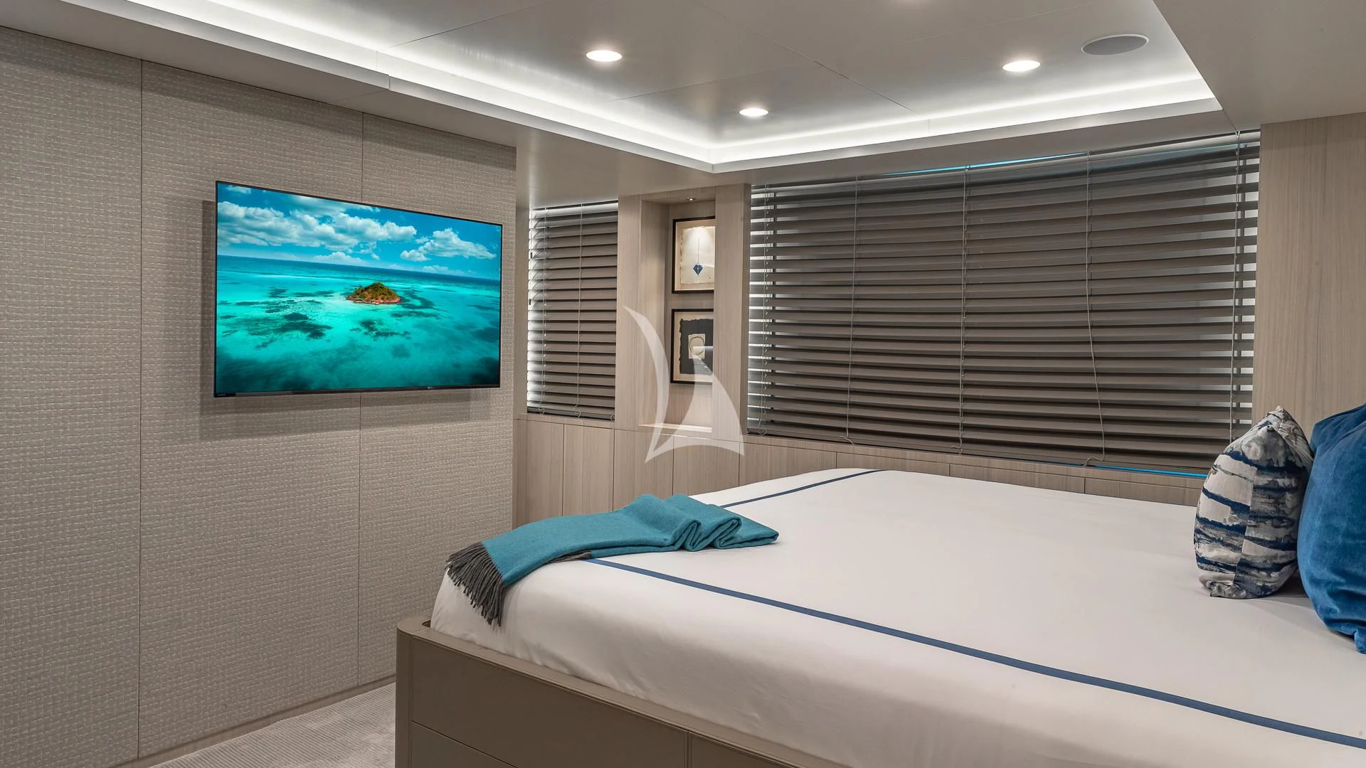 a room with a bed and a television on the wall aboard REVERIE Yacht for Sale
