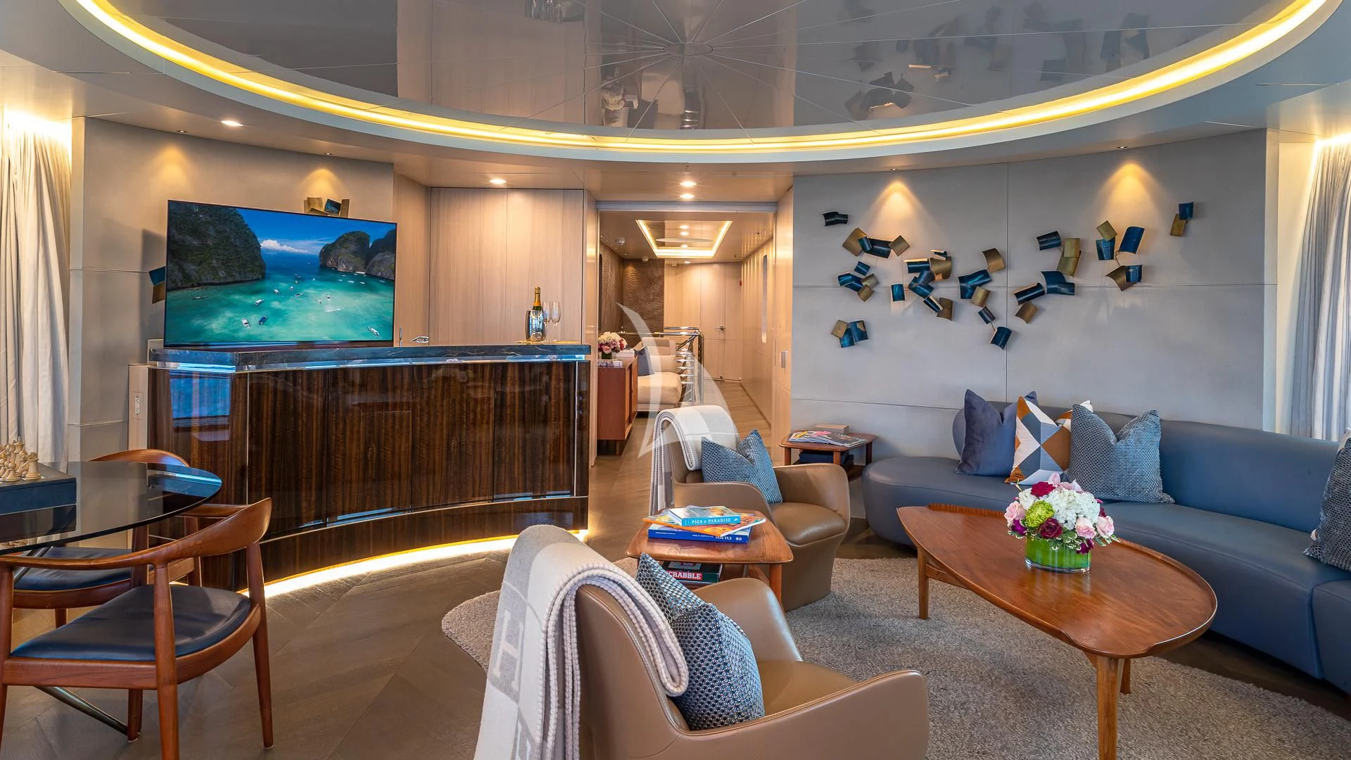 a living room with a blue couch and a television aboard REVERIE Yacht for Sale