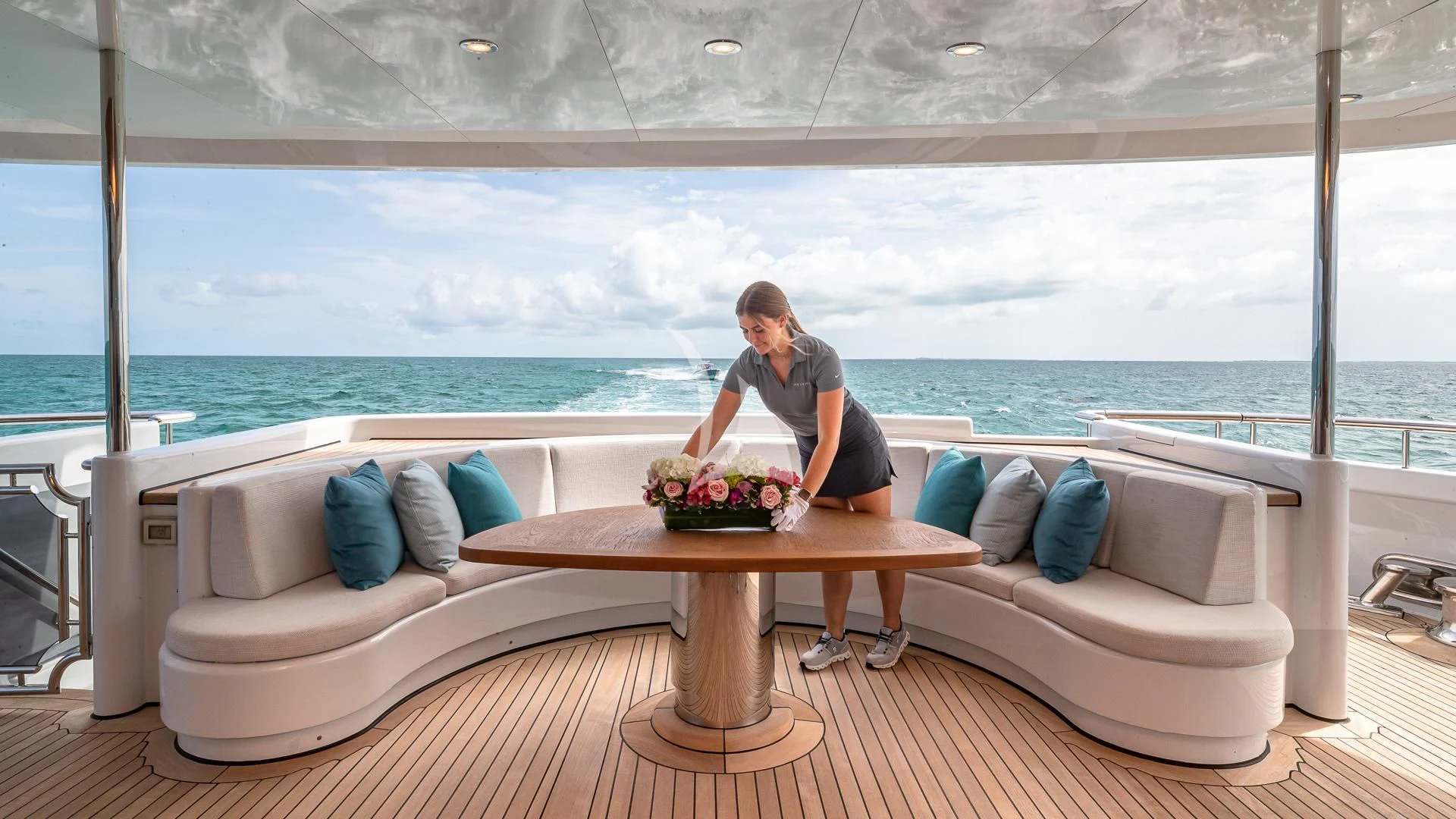 a person sitting on a couch with a bowl of flowers in front of the aboard REVERIE Yacht for Sale