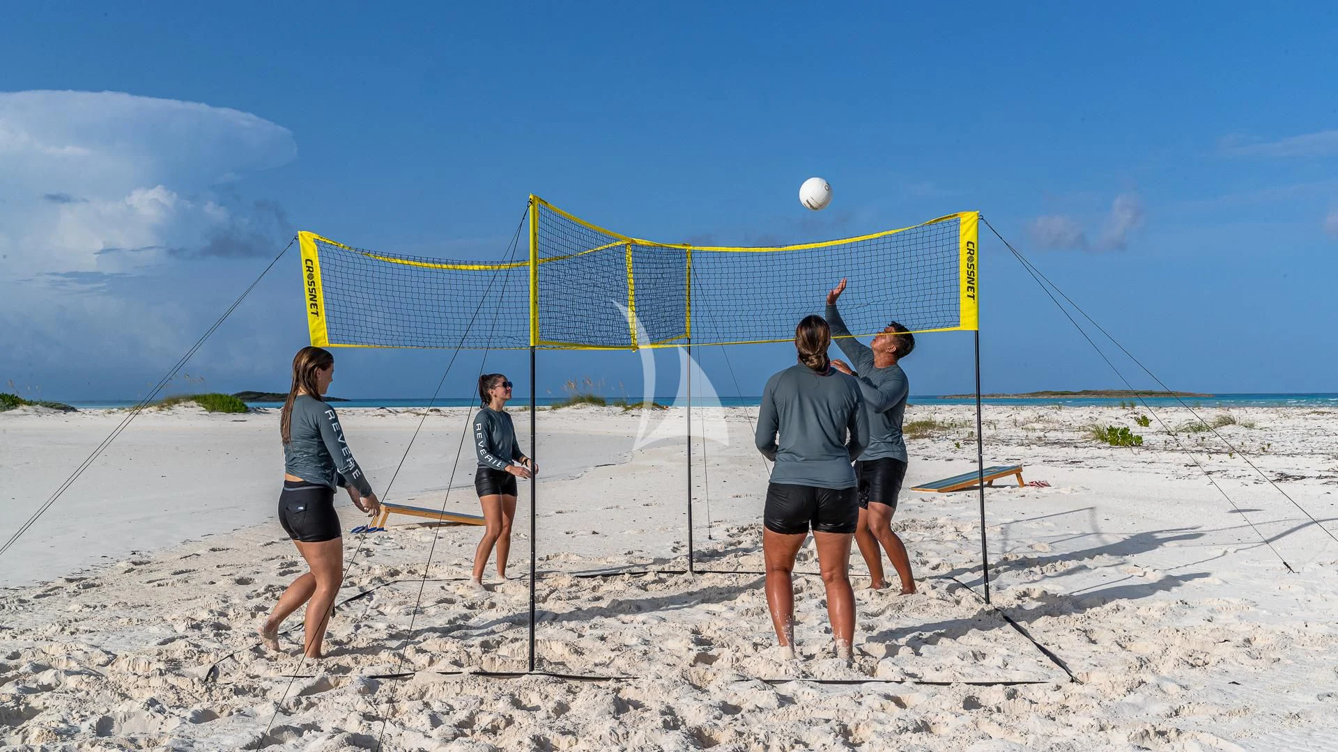 a group of people playing volleyball on a beach aboard REVERIE Yacht for Sale