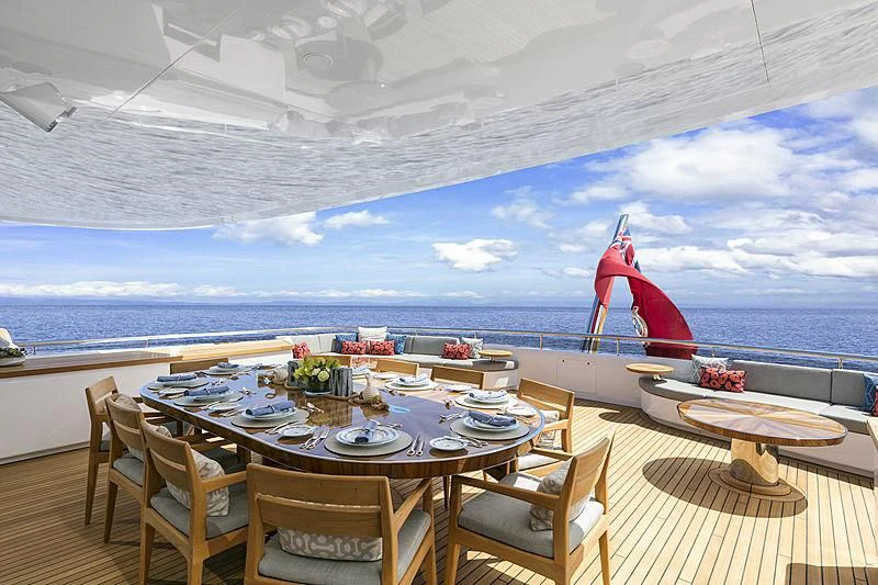 a dining table on a deck overlooking the ocean aboard REVERIE Yacht for Sale