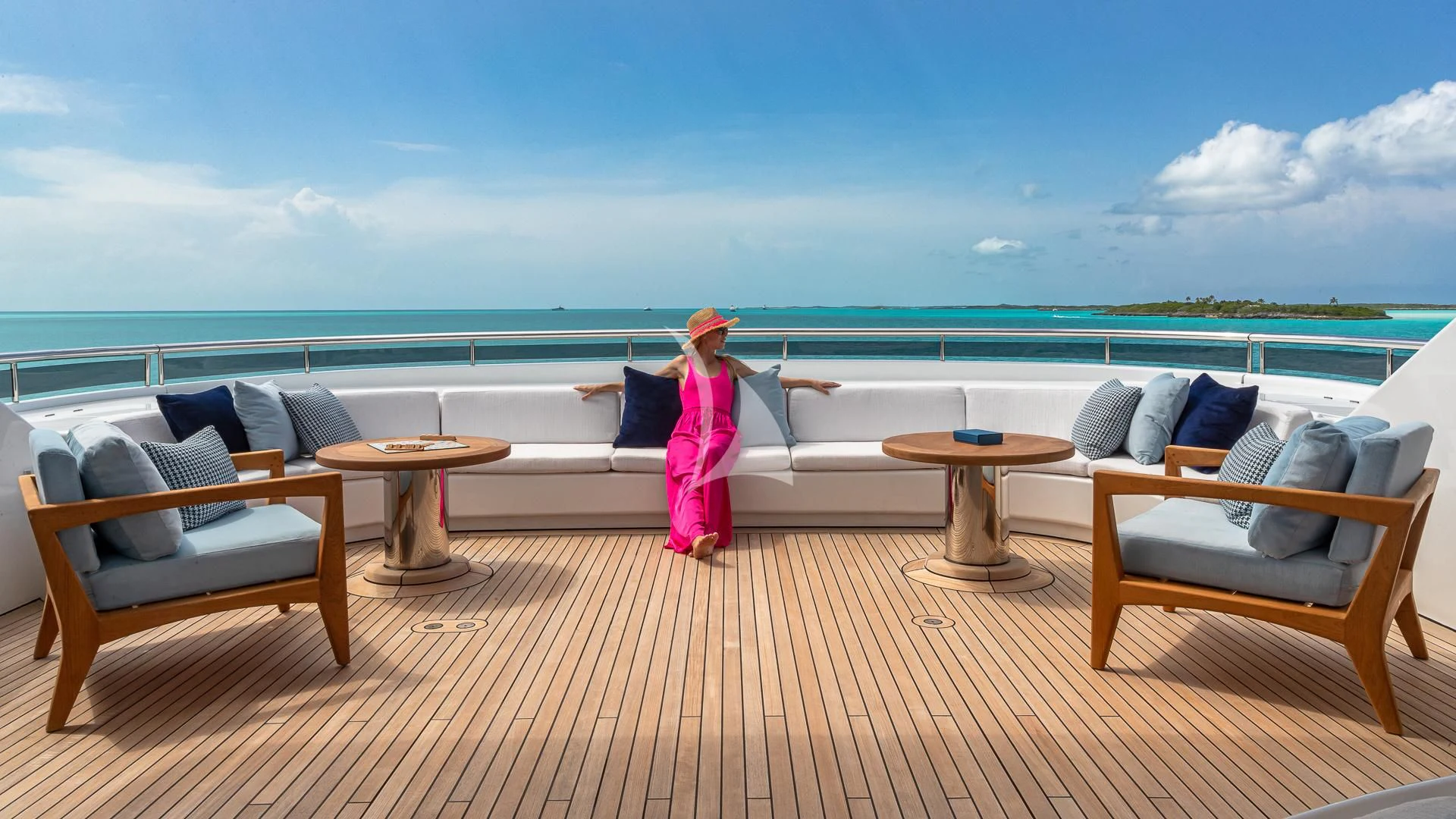 a person sitting on a couch on a deck overlooking the ocean aboard REVERIE Yacht for Sale