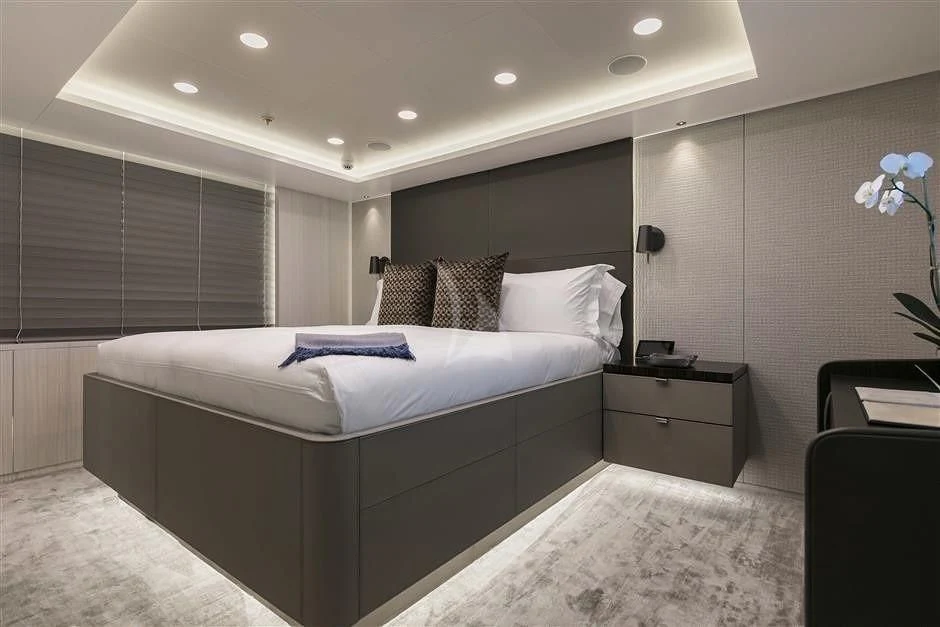 a bedroom with a bed and a desk aboard REVERIE Yacht for Sale